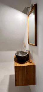ein Bad mit einem schwarzen Waschbecken und einem Spiegel in der Unterkunft Kaple svaté Markéty in Saar