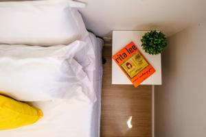 Una cama con un libro y una planta al lado en Allianz Parque - Apartamento com Vista Incrível e Academia, en São Paulo