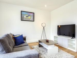 a living room with a couch and a flat screen tv at Apartment Heathrow Central House-4 by Interhome in Hounslow