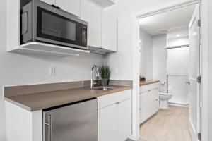 cocina blanca con fregadero y microondas en Perfect Peak, Unit 2B, en Fraser