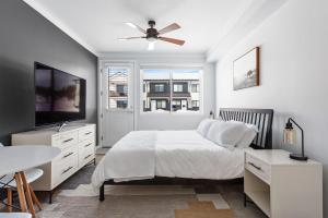 a white bedroom with a bed and a ceiling fan at Perfect Peak, Unit 2B in Fraser