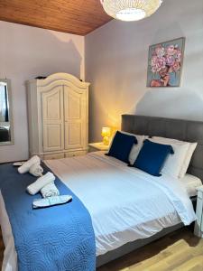 a bedroom with a large white bed with blue pillows at The Port House Sea Breeze in Agios Georgios