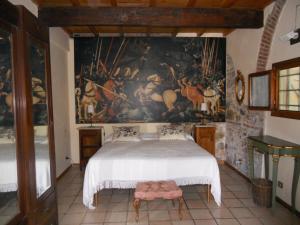 a bedroom with a bed with a painting on the wall at Agriturismo Le Macine in Florence