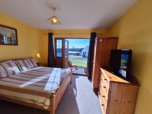 um quarto com uma cama e uma televisão de ecrã plano em Beautiful Lakeside Holiday Home (6 Portinode Cottages) em Enniskillen