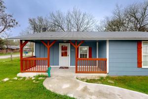 uma pequena casa azul com um alpendre frontal vermelho em Cowboy Cottage em Bandera