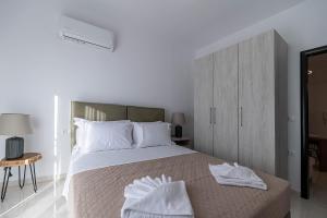 a bedroom with a bed with two towels on it at Archangelos SKY Junior Apartment in Archangelos +7 photos
