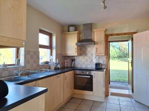 uma cozinha com um lavatório e um fogão em Beautiful Lakeside Holiday Home (6 Portinode Cottages) em Enniskillen
