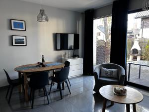 a living room with a table and chairs and a television at KAMI Ferienwohnungen in Pobierowo