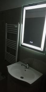 ein Bad mit einem Waschbecken, einem Spiegel und einem Fenster in der Unterkunft Apartament 2 camere Ultracentral in Tîrnăveni
