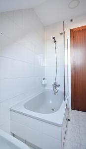 ein weißes Badezimmer mit Badewanne und Dusche in der Unterkunft Apartamento con terraza frente al mar en O Grove in O Grove