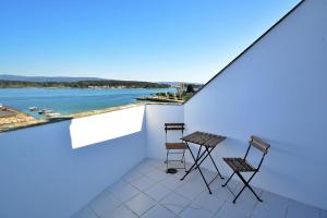 a balcony with two chairs and a view of the water at Apartamento con terraza frente al mar en O Grove in O Grove