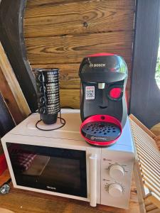 a red and black mixer sitting on top of a microwave at Bungalow Ti Koko in Le Gosier