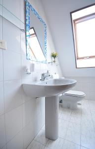 W białej łazience znajduje się umywalka i lustro. w obiekcie Apartamento con terraza frente al mar en O Grove w mieście O Grove