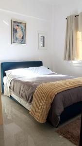 Un dormitorio con una cama con una manta. en Patras Cozy Nest in the Vibrant City Center en Patras