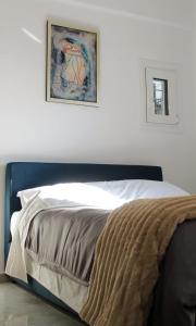 a bed in a bedroom with a picture on the wall at Patras Cozy Nest in the Vibrant City Center in Patra