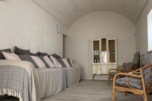 - une chambre avec un lit et une chaise dans l'établissement Trullanto, à Francavilla Fontana