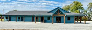 ein blaues Gebäude mit grauem Dach in der Unterkunft Angler’s Inn in Grove