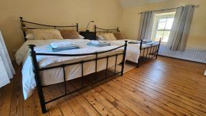 2 łóżka w sypialni z drewnianą podłogą w obiekcie The Home House w mieście Plumb Bridge