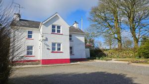 a white and red house on the side of a road at The Home House in Plumb Bridge