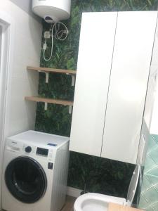 a bathroom with a washing machine and a toilet at ЖК Новый Степной in Karagandy