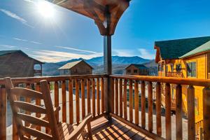 a deck with a chair and a view of the mountains at Cabin 6BR/8BA Smokies Views in Gatlinburg