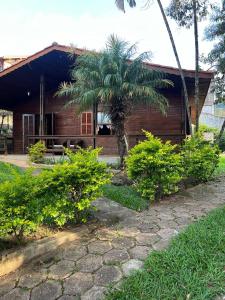 ein Haus mit einer Palme davor in der Unterkunft Chácara (Condomínio Portal dos Nobres- Atibaia/SP) in Atibaia