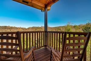 two chairs sitting on the deck of a cabin at Cabin 6BR/8BA Smokies Views in Gatlinburg