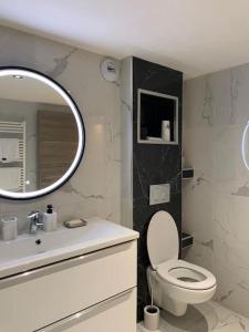 a bathroom with a toilet and a sink and a mirror at Superbe appartement JO 2024 in Plaisir
