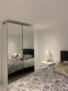 a bedroom with two beds and a mirror at Superbe appartement JO 2024 in Plaisir