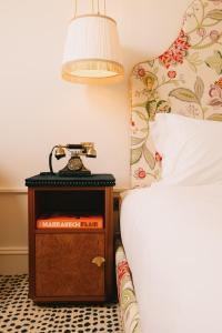 um quarto com uma cama e uma mesa de cabeceira com um relógio em The Leinster em Dublin