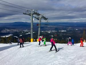 a group of people skiing down a snow covered ski slope at Guest House Niya in Beli Iskar