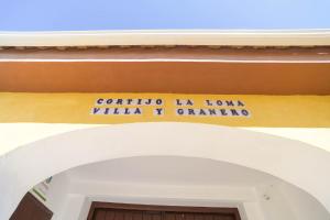 una entrada a un edificio con un letrero sobre una puerta en Casa Rural "compartida" La Loma Granero, en Granada