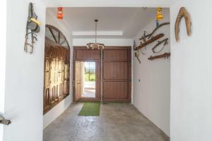 a hallway with a wooden door and a green rug at Casa Rural "compartida" La Loma Granero in Granada
