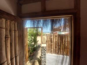 una puerta corredera de cristal con vistas a una valla en Casita Privada Máncora - Playa & Piscina, en Máncora