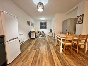 uma cozinha e sala de estar com uma mesa e um frigorífico em Immaculate 2-Bed Apartment Town Centre em Cheltenham