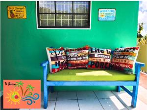 a green wall with a bench with pillows on it at Ti Brico Gros Islet Bungalow in Gros Islet