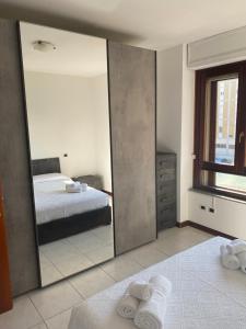 einen Spiegel in einem Schlafzimmer mit einem Bett und einem Fenster in der Unterkunft Poetto Beach in Cagliari