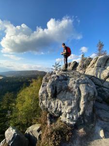 Ein Mann steht auf einem felsigen Berg in der Unterkunft Siedem Łanów in Radków