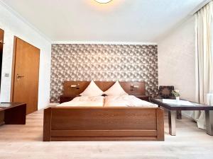 a bedroom with a large bed and a wall at Hotel Deutsches Haus mit WLAN und Parkplatz, HDZ und Kliniken in der Nähe, direkt an der A2 und A30 gelegen in Löhne