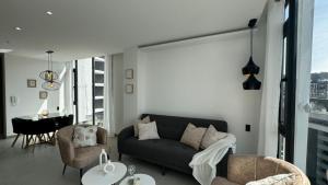 a living room with a couch and chairs and a table at Harmony Skyline Suite14th Floor View & Luxury Spa in Quito