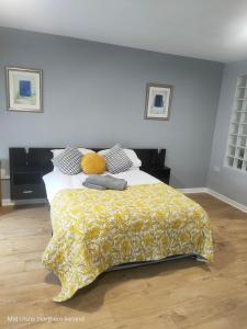 a bedroom with a bed with a yellow blanket at The Oldtown Apartments in Cookstown