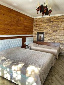 a bedroom with two beds and a brick wall at Villa SUNRISE in Dospat