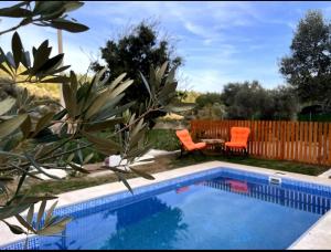 a swimming pool with two orange chairs and a table next to a fence at Flow Urla in Izmir