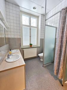 a bathroom with two sinks and a toilet at Hostel Bjorkenheim in Seinäjoki