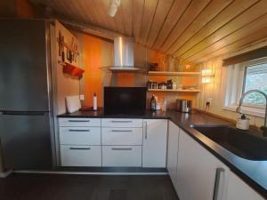 cocina con armarios blancos y nevera de acero inoxidable en Holiday Home Sybille - all inclusive - 30km from the sea by Interhome, en Fårvang