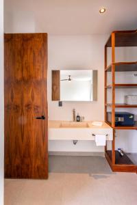 uma casa de banho com um lavatório e uma porta de madeira em CASA MILAH TULUM 8BDR BEACH FRONT PRIVATE-CHEF VILLA WEDDINGS-RETREATS-FAMILY GATHERINGS em Akumal
