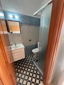 a bathroom with a toilet and a sink at Sofia & Lakis House in Ormos Panagias