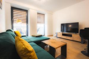 een woonkamer met een groene bank en een televisie bij Apartmán Banská Bystrica centrum in Banská Bystrica