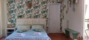 een slaapkamer met een bed met bloemenbehang bij Casa Vacanza Nonno Gigi in Mandello del Lario