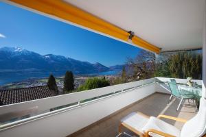 a balcony with a view of the mountains at VISTA LAGO casa Hulya in Orselina
